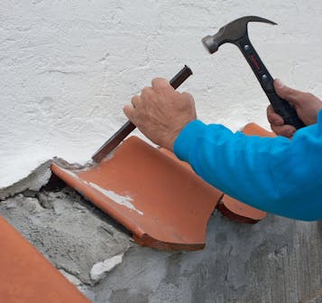 Fjern de ødelagte teglsteinene med hammer og en meisel Fjern de ødelagte teglsteinene med hammer og en meisel